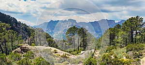 Low-angle of mountains of Corsica against cloudy sunlit sky France