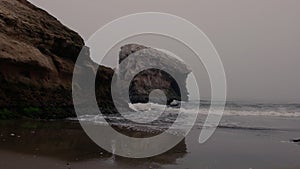 Low angle: Pacific waves lap ashore at an outcropping, Natural Bridges Beach