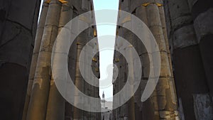 Low angle panning in between uplight columns Luxor temple Egypt