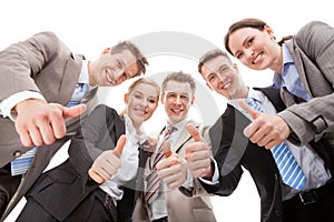 Low angle portrait of confident business team showing thumbs up against white background