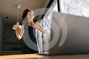 Low-angle portrait of sporty young woman working out, doing warming up exercise watching fitness video online on laptop