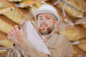 Low angle portrait young builder holding clipboard