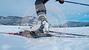 LOW ANGLE: Professional nordic skiing athlete pushes off her ski and poles.