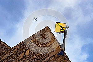 Low angle shot of an airplane flying over a building in the clears sky