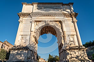 Low-angle shot of the Arch of Titus in Rome with a blue sky in the background