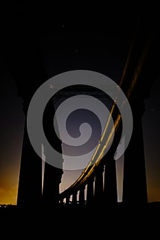 Low angle shot of an Architectural structure with rocky columns at night with little light