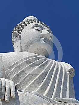 Low angle shot of a big white Buddha statue isolated on a blue background, Phuket, Thailand