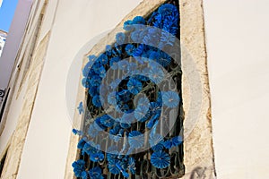 Low angle shot of a blue paper flowers decorating a window