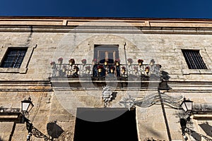 Low angle shot of a building's entrance with lights and balcony with flowerpots