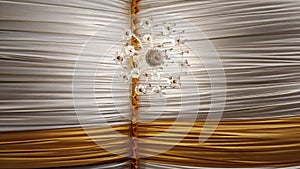 Low angle shot of a chandelier in the ceiling with white and yellow textiles