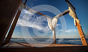 Low angle shot of an empty wooden gazebo near the sea under a blue sky