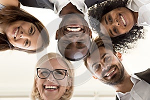 Low angle shot of excited work employees standing in circle