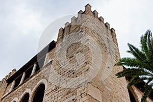 Low angle shot of an exterior brick wall of the Almudaina Palace under the clouded sky