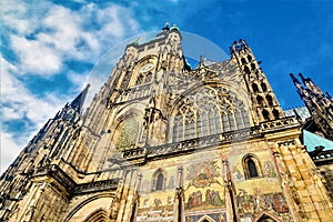 Low angle shot of the facade of St. Vitus Cathedral against a blue sky in Prague, Czech Rebublic