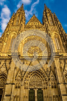 Low angle shot of the facade of St. Vitus Cathedral in Prague, Czech Republic, against a blue sky