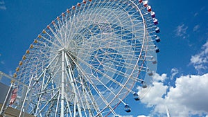 Low angle shot of a Ferris wheel and a blue sky