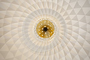 Low angle shot of the golden crystal chandelier and beautiful patterns in Inya Lake Ballroom