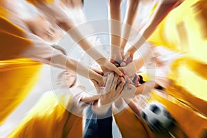 Low angle shot of a group of sports team forming a huddle with their hands photo