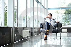 Low angle shot of a handsome young businessman in a stylish modern office space with large windows.