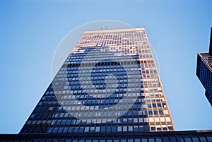 Low angle shot of a high rise building with see-through windows under the clear blue sky