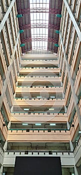 Low angle shot of the interior of a tall building. The roof has skylight elements so that natural light enters elegantly into the