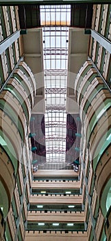 Low angle shot of the interior of a tall campus building, in an art deco style of interior architecture. Skylight elements on the