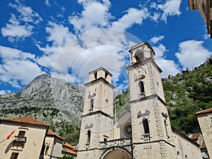 Low angle shot of Katedrala Svetog Tripuna cathedral on blue cloudy sky background in Montenegro