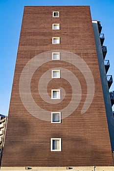 Low angle shot of a modern building wall and window against a blue sky