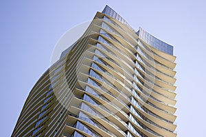 Low angle view of a modern corporate building with yellowish overhangs in each floor. photo