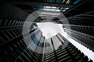 Low angle shot of modern glass city buildings with clear sky background.