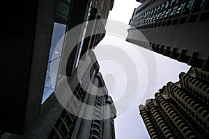 Low angle shot of modern glass city buildings with clear sky background.