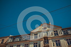 Low angle shot of an old building under the blue sky and electrical cords