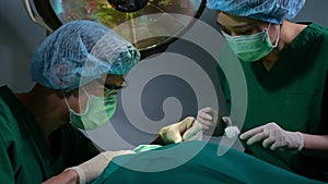 Low Angle Shot of Professional surgeons team performing surgery in operating room, surgeon, Assistants, and Nurses Performing