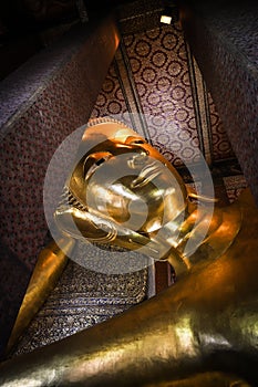 Low angle shot of reclining buddha at the Wat Arun Ratchawararam temple complex in the Bangkok