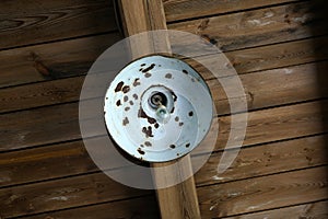 Low angle shot of a rusty lamp hanging on a wooden ceiling