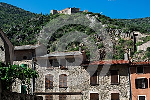 Low-angle shot Saint-Martin-du-Canigou Abbaye hill with buildings on the bottom, sky background