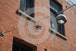 Low angle shot of shoes hanging from a powerline near building