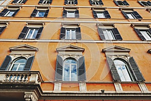 Low angle shot showing details of European classic building with beautiful Italian architectural style window panels