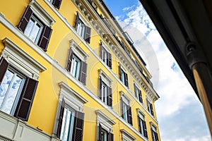 Low angle shot showing details of European classic building with beautiful Italian architectural style window panels