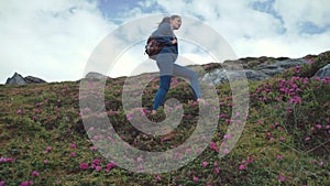 Low angle shot of a smiling young female backpacker in casual wear looking around with enjoyment, and going down the