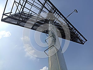 Low-angle shot of a steel structure of a billboard against a blue sky