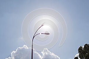 Low angle shot of a street lamps silhouette on the background of heavily clouded dramatic winter sunset skies with the setting sun