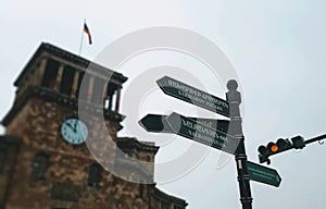 Low-angle shot of street signs and the clock tower in Republic Square, Yerevan, Armenia.