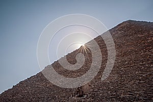 Low angle shot of the sun shining from behind the Great Pyramid of Giza in Egypt