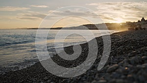 Low angle shot of sunset on a pebble beach of Nice photo