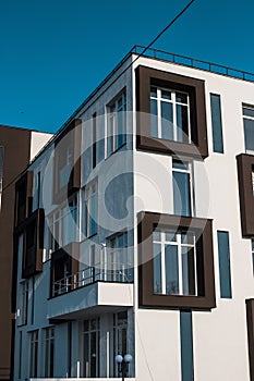 Low angle shot of a tall white and brown apartment building