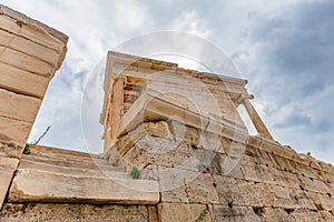 Low angle shot of the Temple of Athena Nike in Athens, Greece against a gray cloudy sky