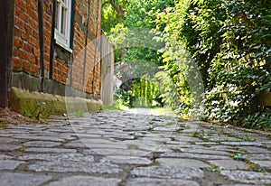 Low angle shot to a historical cobblestone alley with red half-timbered houses