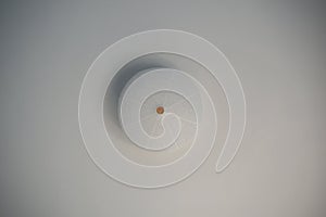 Low angle shot of a white luminaire on a white ceiling