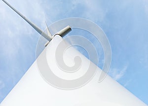 Low angle shot of a wind energy generator turbine under the blue sky